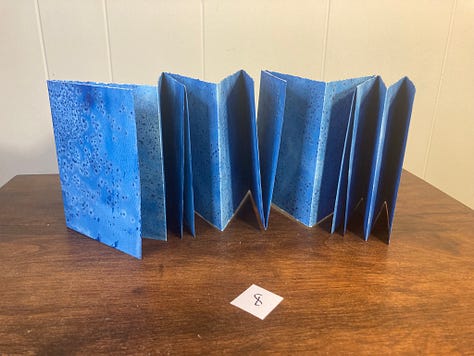 folded paper fanned out in various shades of blue.