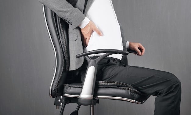 Businessman with back pain sitting in office chair.
