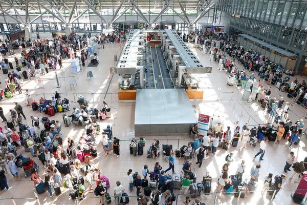 A view from above of a crowded airport with long lines of people. A view from above of a crowded airport with long lines of people.