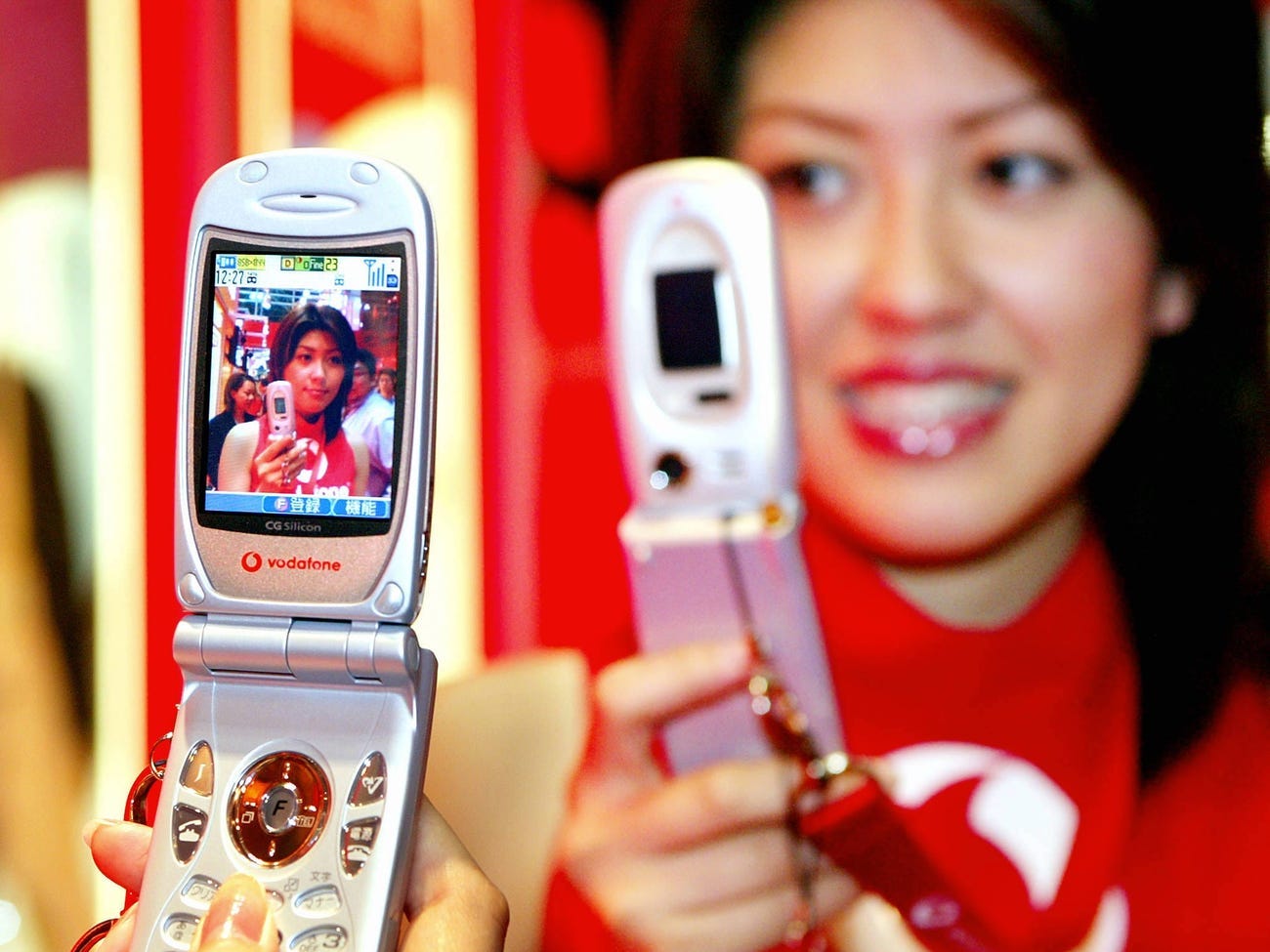 woman holding J-SH53 mobile phone in 2003