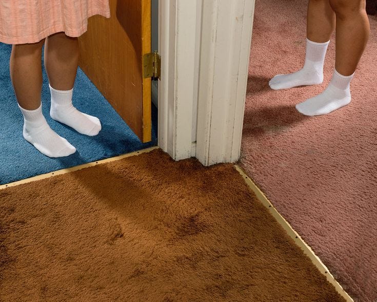 This may contain: two people standing in front of a door with their feet up on the floor and one person wearing white socks