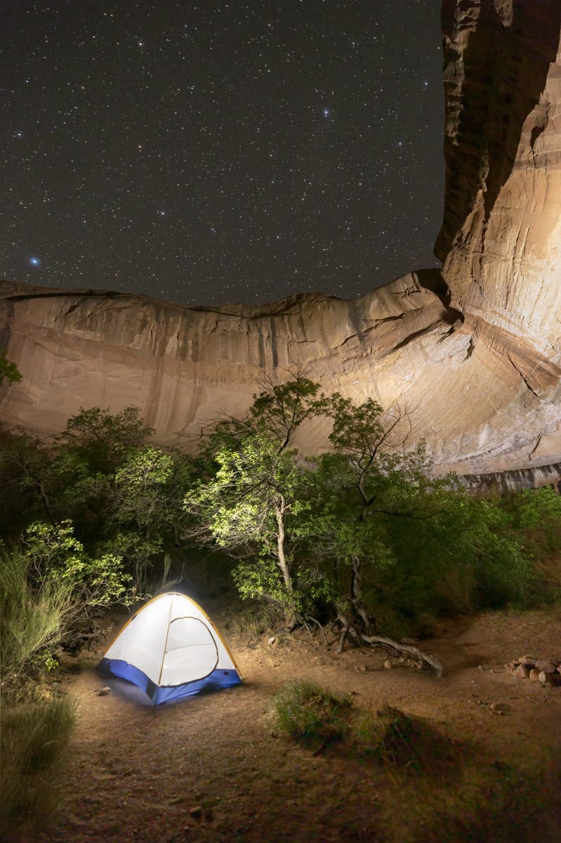 A glowing tent in a desert alcove under the stars.