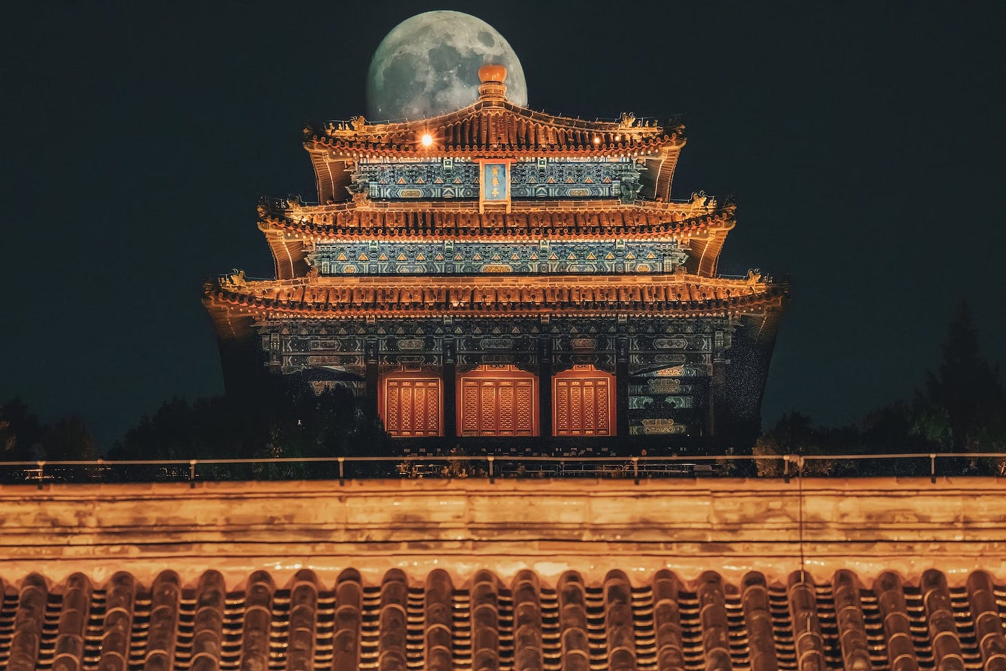 Fotografia em cores do Pavilhão Wanchun em Jingshan, Pequim. Ao fundo, sobre o telhado, vê-se a lua cheia. Fotografia em cores do Pavilhão Wanchun em Jingshan, Pequim. Ao fundo, sobre o telhado, vê-se a lua cheia.