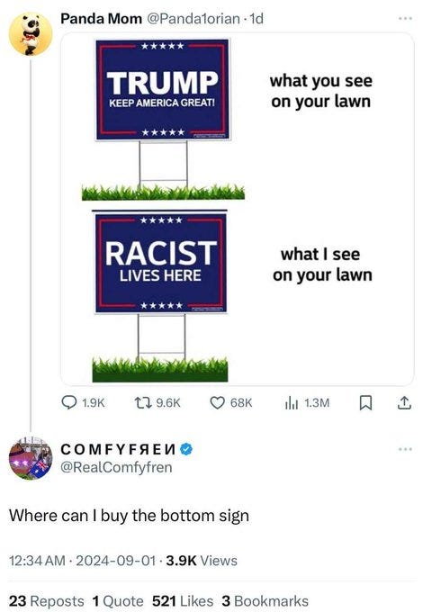 Two lawn signs on grass. The top sign is blue with white text reading "KEEP TRUMP GREAT AMERICA GREAT." The bottom sign is blue with white text reading "RACIST LIVES HERE."