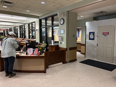 Pictures inside the Saratoga Springs library include the walls erected for elevator reapair and signs reminding people not to bring strollers on stairs and where to get coffe.