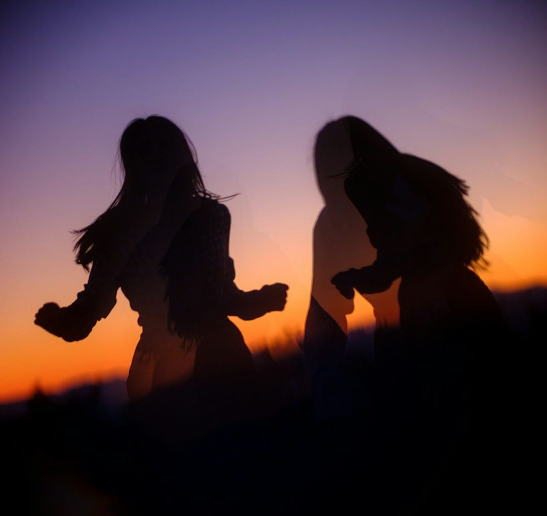 silhouette of 2 women kissing during sunset