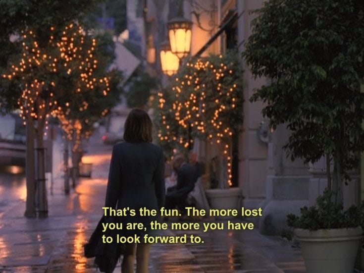 This may contain: a woman is walking down the street in the rain