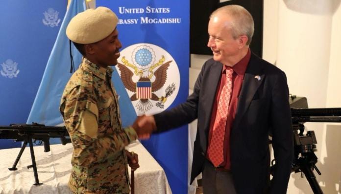 A person shaking hands with a soldier Description automatically generated A person shaking hands with a soldier Description automatically generated