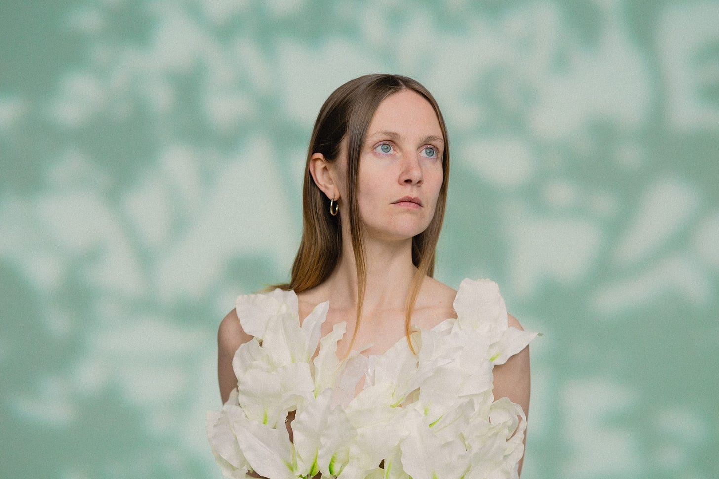 A photo of Frankie Archer, a young woman wearing a dress that appears to be made out of large white flowers.