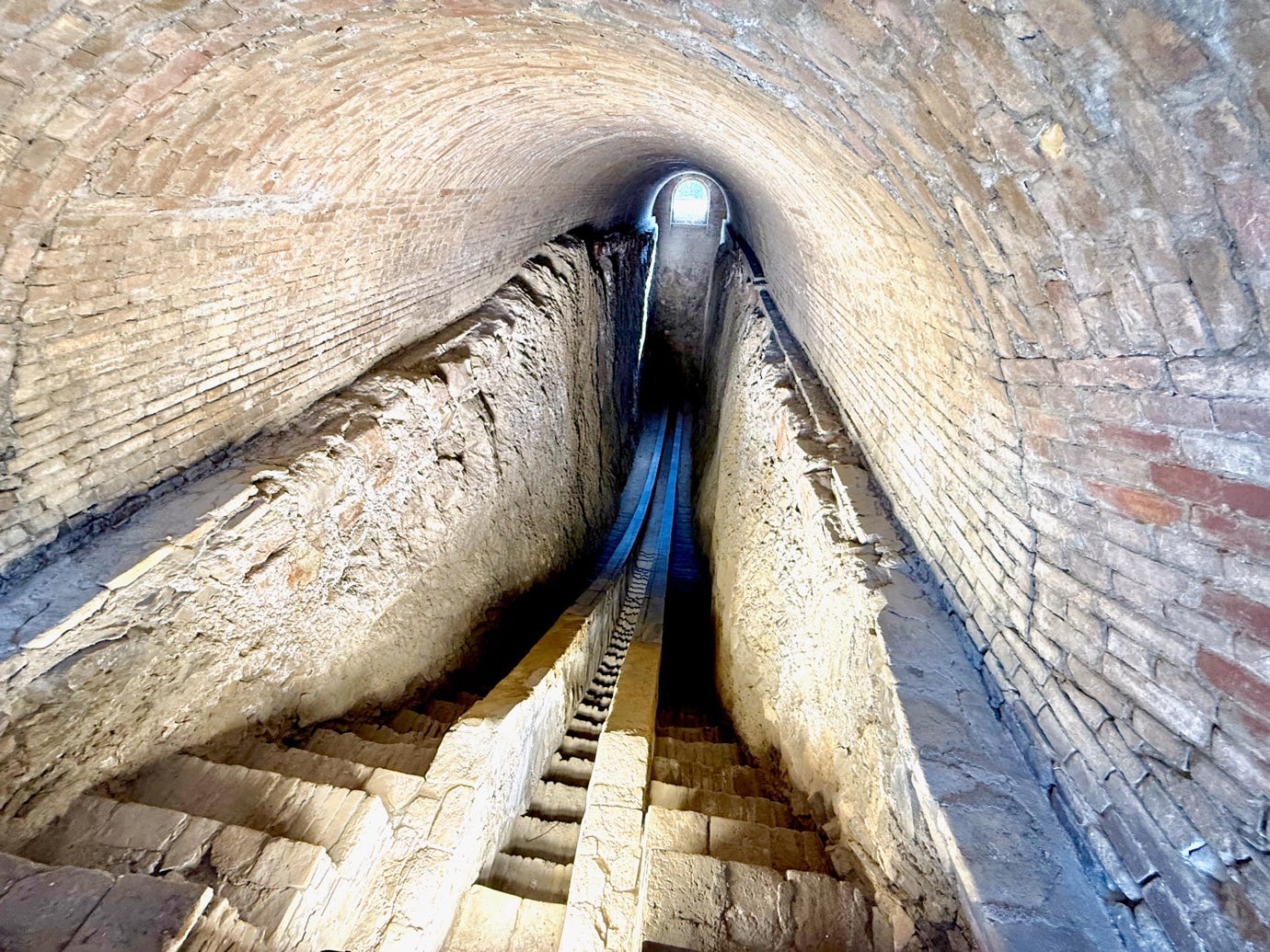A stone tunnel with a stone staircase

AI-generated content may be incorrect.