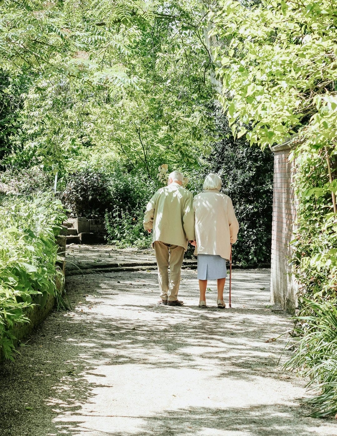 man and woman walking on road during daytime man and woman walking on road during daytime