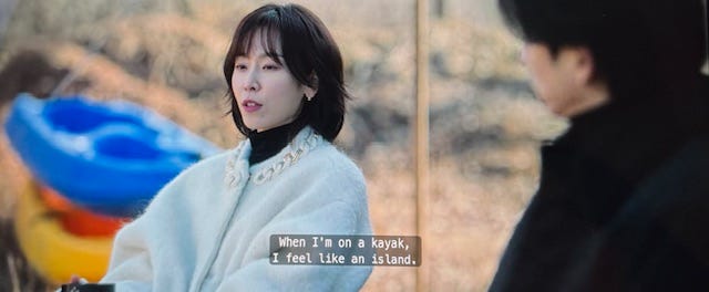 Noh In-Ji talks about kayaking outside of the lake house in a white fuzzy sweater at the lake house in episode 6 of The Trunk on Netflix
