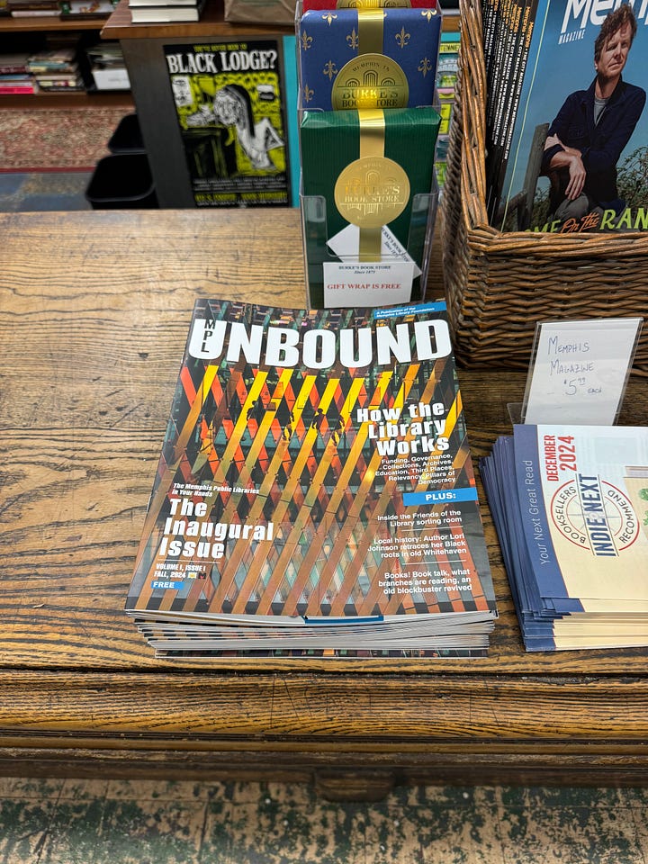 Two photos of the cover of MPL Unbound magazine, first in a tiered magazine rack at Novel bookstore and second laying in a stack on a store counter.