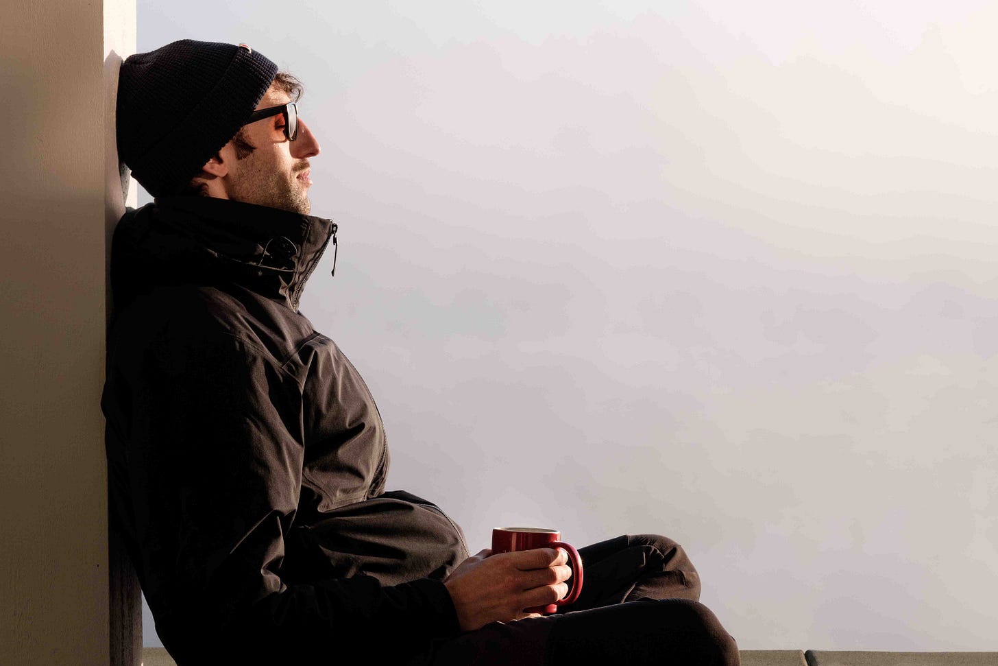 A person sits cross-legged on the ground at sunrise, eyes closed in quiet reflection. Mist drifts behind them, glowing golden in the morning light, softening the edges of the world. The atmosphere is calm and meditative, capturing a fleeting moment of stillness. A person sits cross-legged on the ground at sunrise, eyes closed in quiet reflection. Mist drifts behind them, glowing golden in the morning light, softening the edges of the world. The atmosphere is calm and meditative, capturing a fleeting moment of stillness.