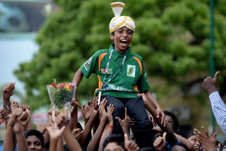 Indian chess prodigy Rameshbabu Praggnanandhaa held up by a cheering crowd
