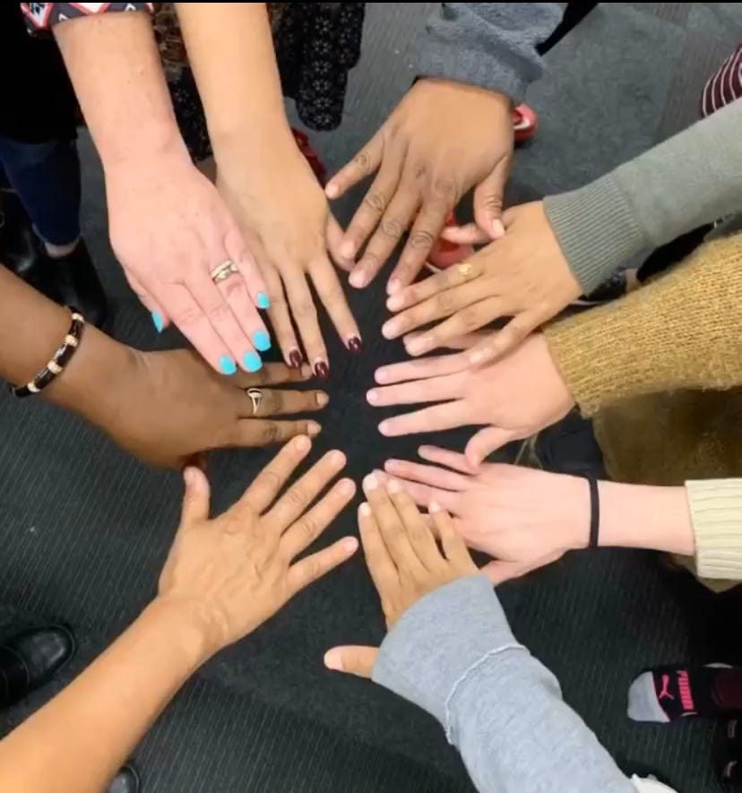 image of 10 different hands held in a loving circle
