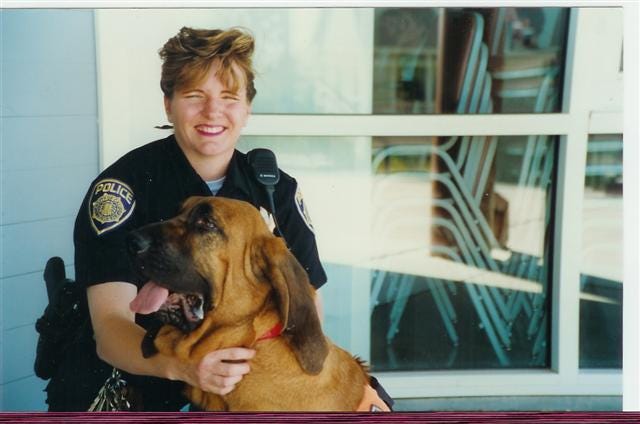Author female police officer in uniform with bloodhound A.J.