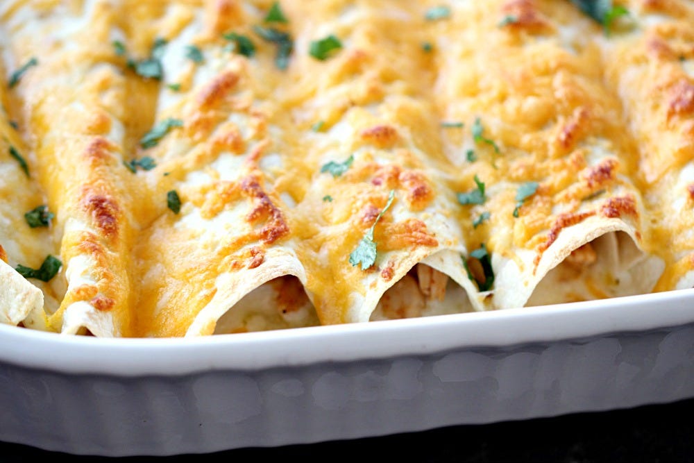 Honey Lime Chicken Enchiladas in white casserole dish