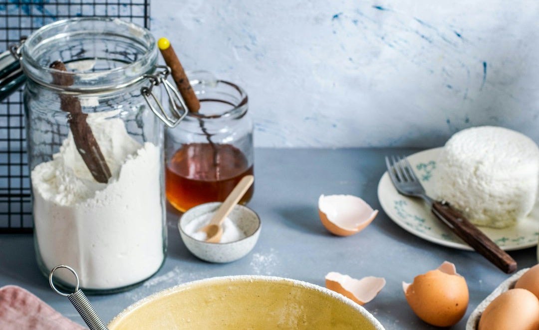 brown mixing bowl with eggs and flour with whisk brown mixing bowl with eggs and flour with whisk