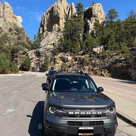 My car near Mt. Rushmore covered in dead bugs and the car wash that came next - and how the car looks now: cleaner.