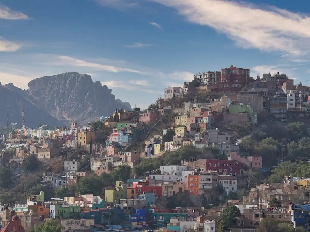Coloured houses on a hillside with mountains in the background