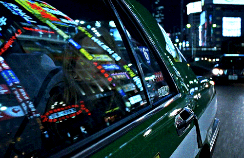 GIF do filme Lost in Translation. Há uma mulher loira dentro de um taxi olhando pela janela vários anúncios de neon em uma cidade grande