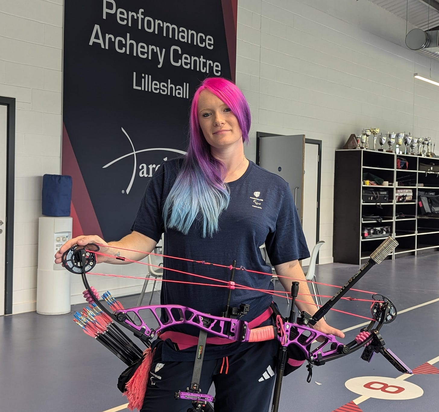 A person with pink hair holding a bow and arrow
Description automatically generated A person with pink hair holding a bow and arrow
Description automatically generated
