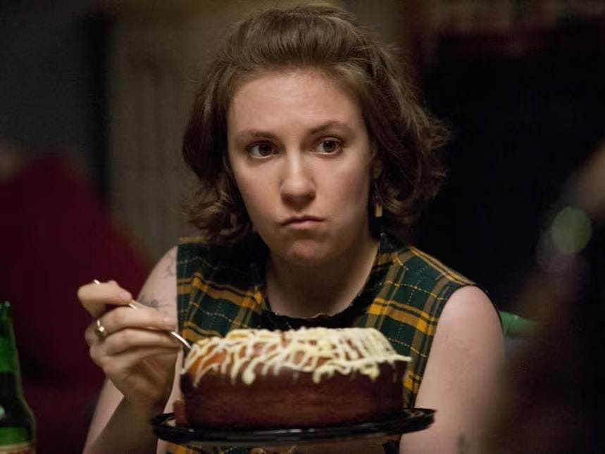 Lena Dunham wears a plaid dress and eats bundt cake in Girls