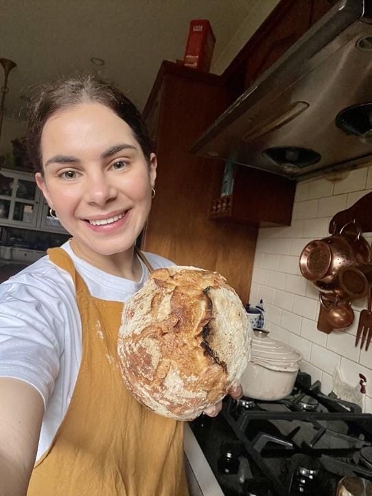A person holding a loaf of bread

Description automatically generated