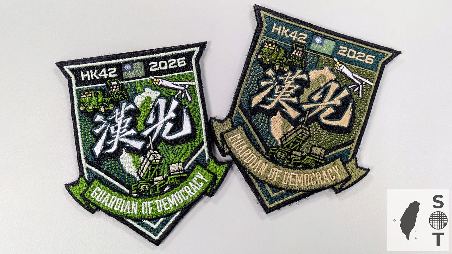 The civilian and military versions of the Han Kuang 42 (HK42) exercise combat patch displayed side by side, showing Taiwan, HIMARS, an ALTIUS-600M drone, and a Patriot PAC-3 air-defense system with the slogan “Guardian of Democracy.”