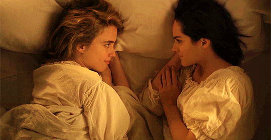 gif: marianne e heloise se olham deitadas na cama