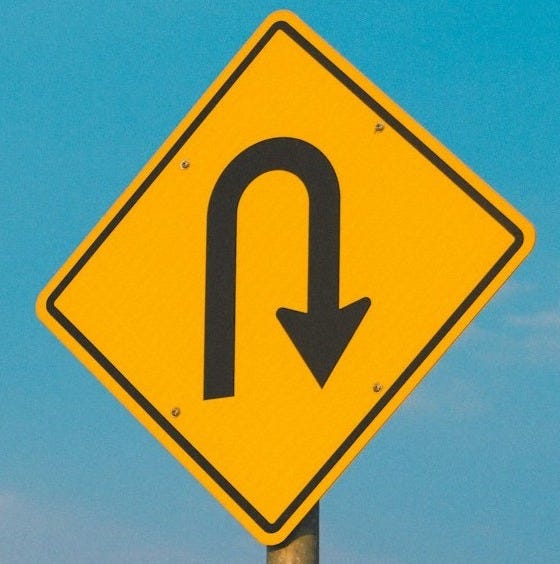 A yellow street sign with an arrow pointing to the right