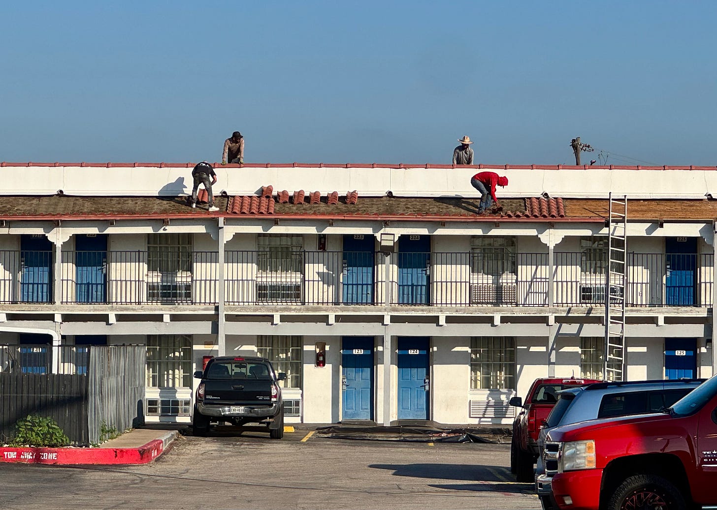 Men roofing a motel