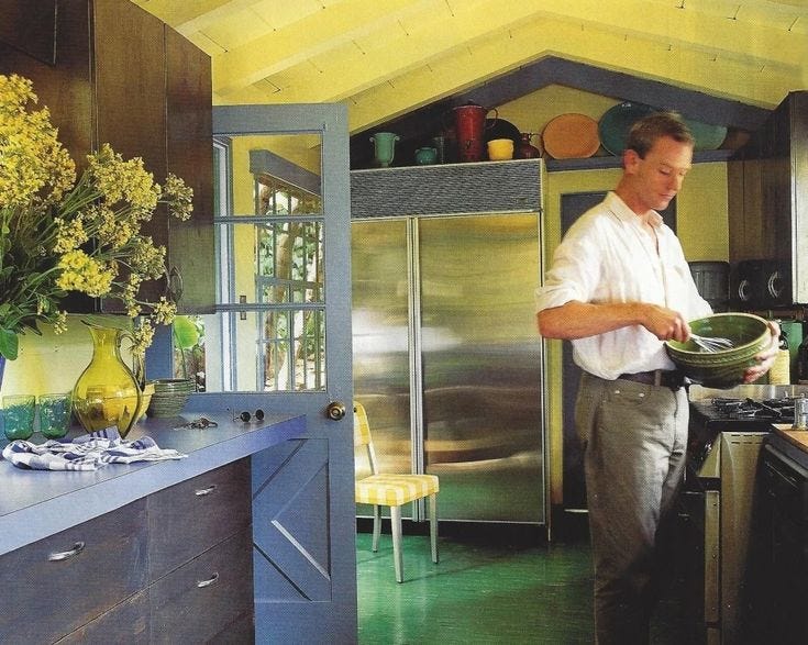 This may contain: a man standing in a kitchen holding a frying pan