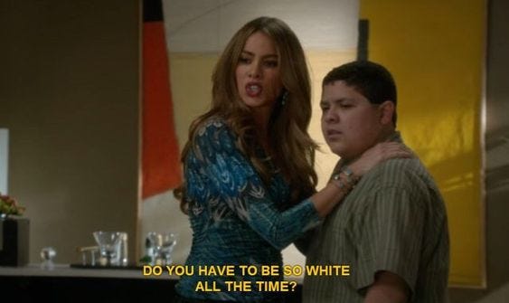Modern Family scene where Gloria is holding her son Manny while looking at her husband Jay, out of frame, and saying, "Do you have to be white all the time?" Modern Family scene where Gloria is holding her son Manny while looking at her husband Jay, out of frame, and saying, "Do you have to be white all the time?"