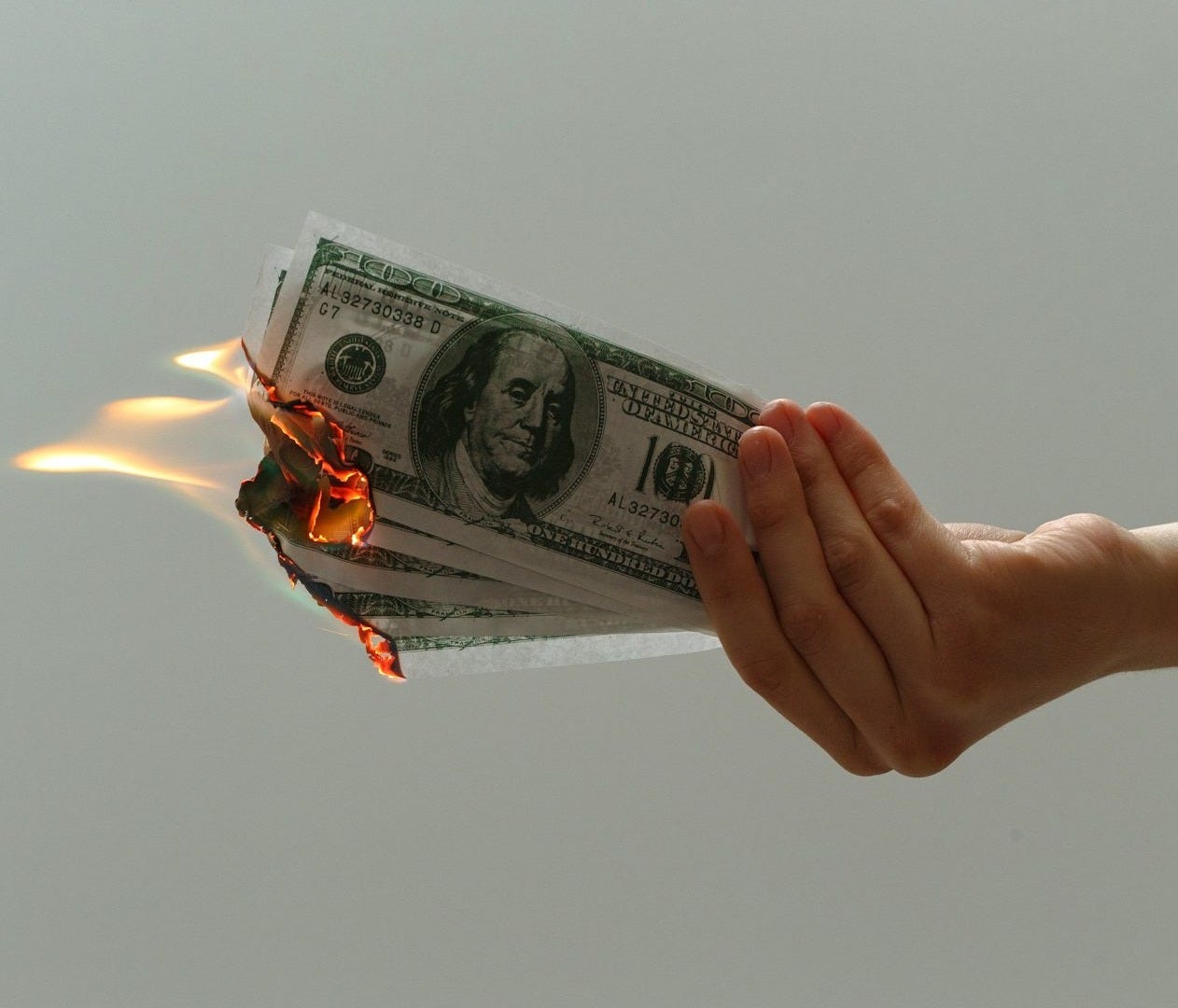 time lapse photography of several burning US dollar banknotes