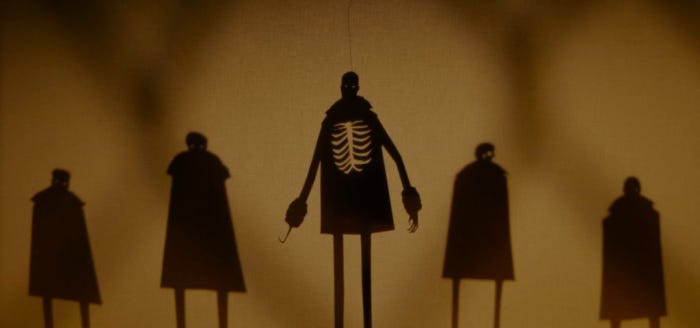amazing kara walker silhouettes; five figures, the one in the middle with exposed ribcage