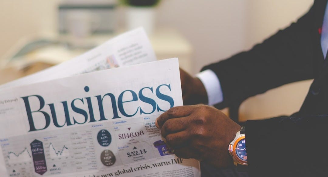 person wearing suit reading business newspaper person wearing suit reading business newspaper