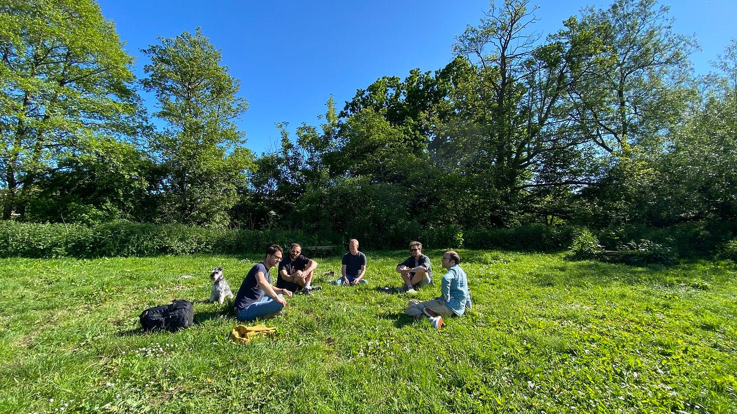 A few of us sit on the grass in a circle outside of the normal studio!