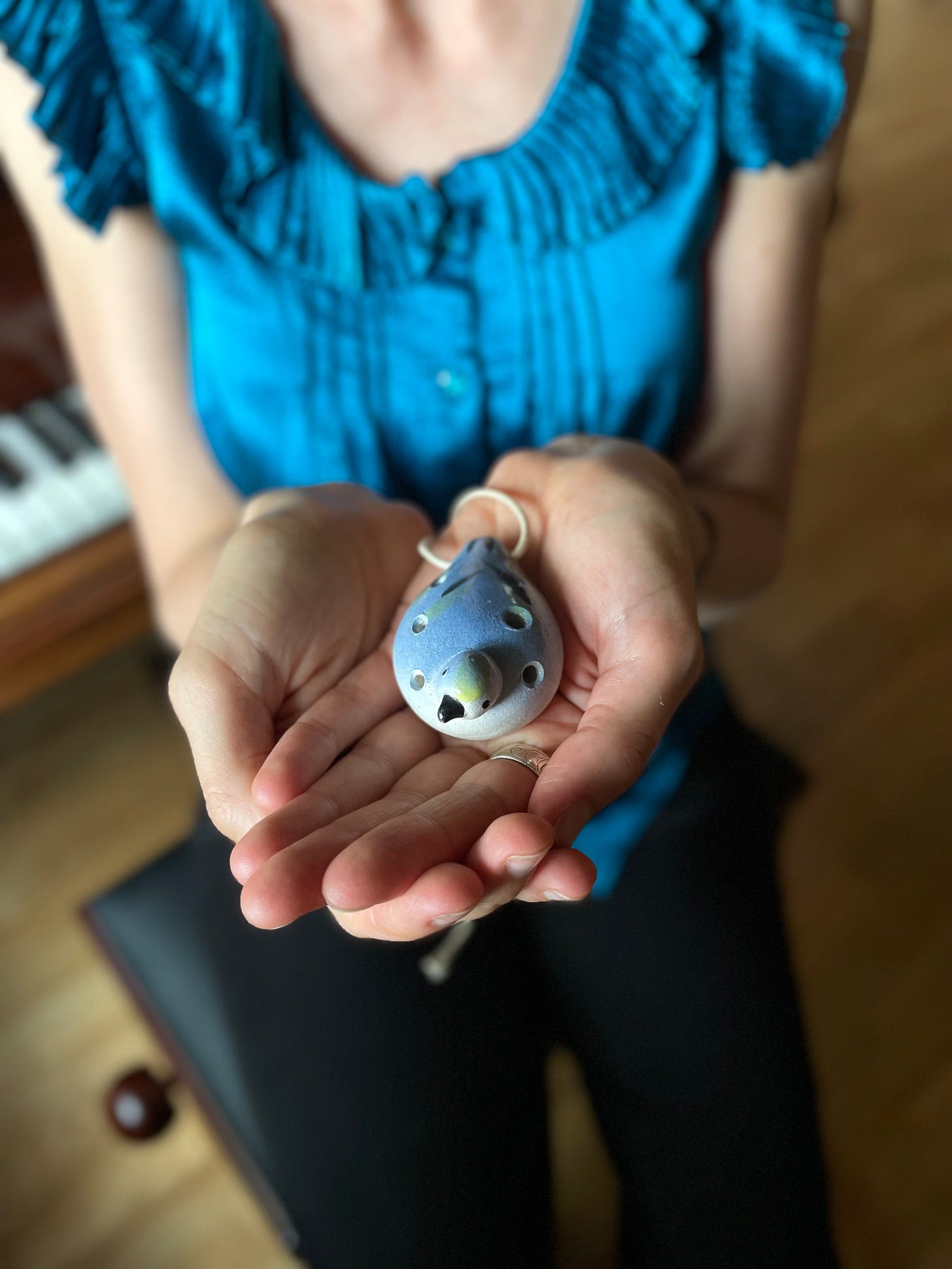 Danielle of Bird Flies Free, holding an ocarina instrument shaped like a bird Danielle of Bird Flies Free, holding an ocarina instrument shaped like a bird