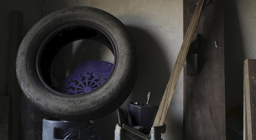 a couple of large pots sitting next to a tire a couple of large pots sitting next to a tire