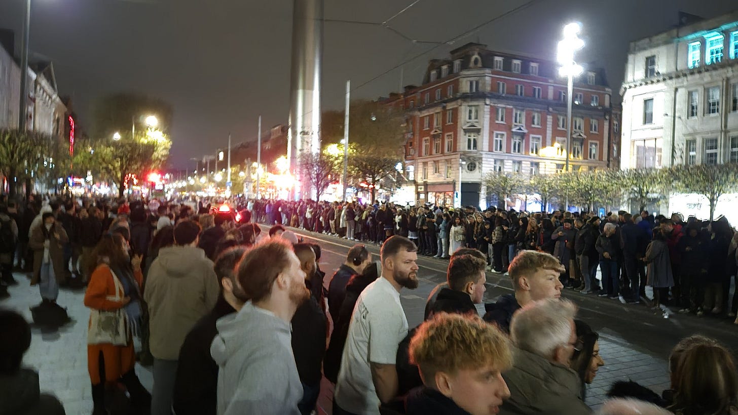 People lining up beside the road en masse