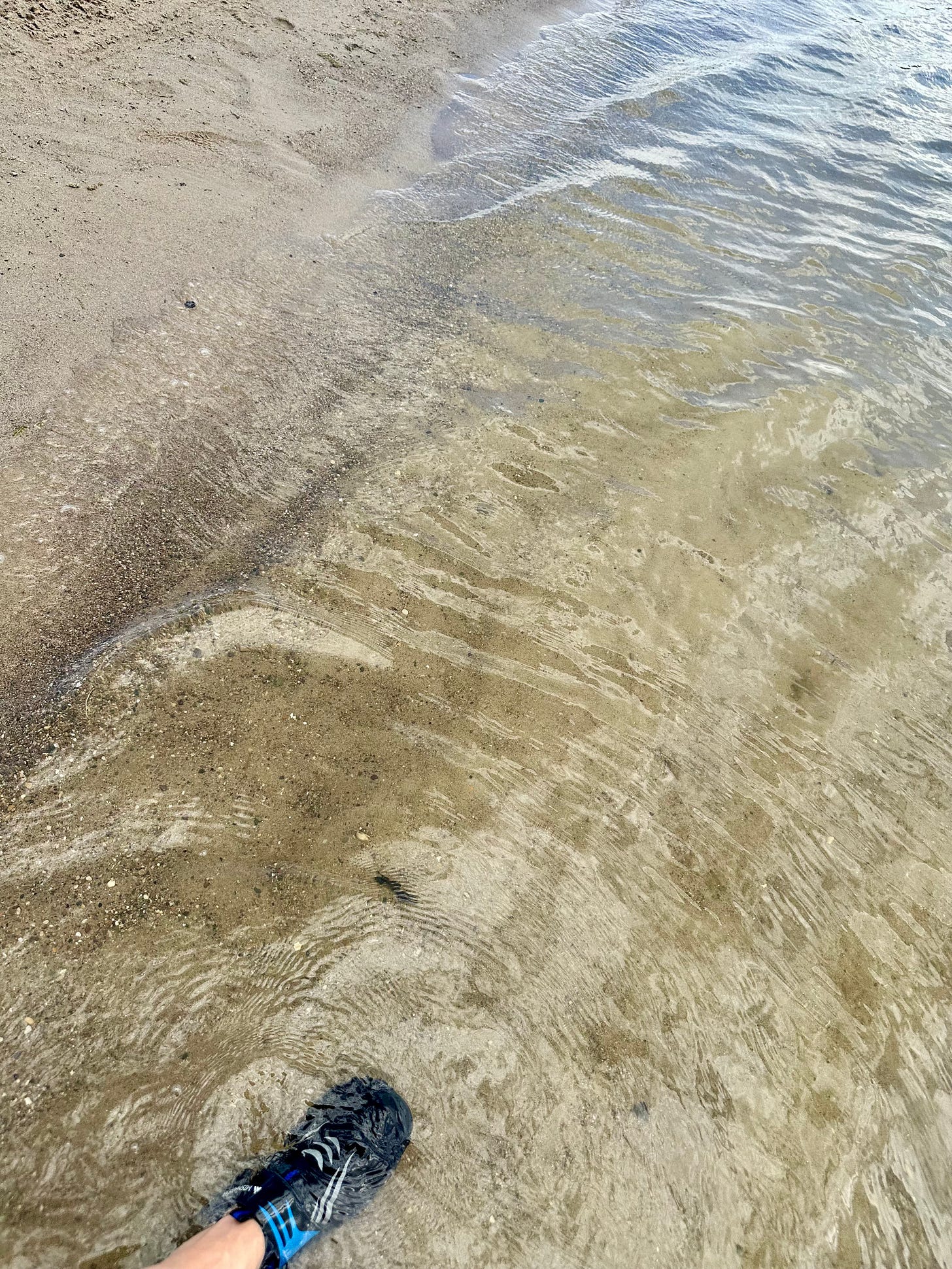 Foot in the water & sand of a lake Foot in the water & sand of a lake