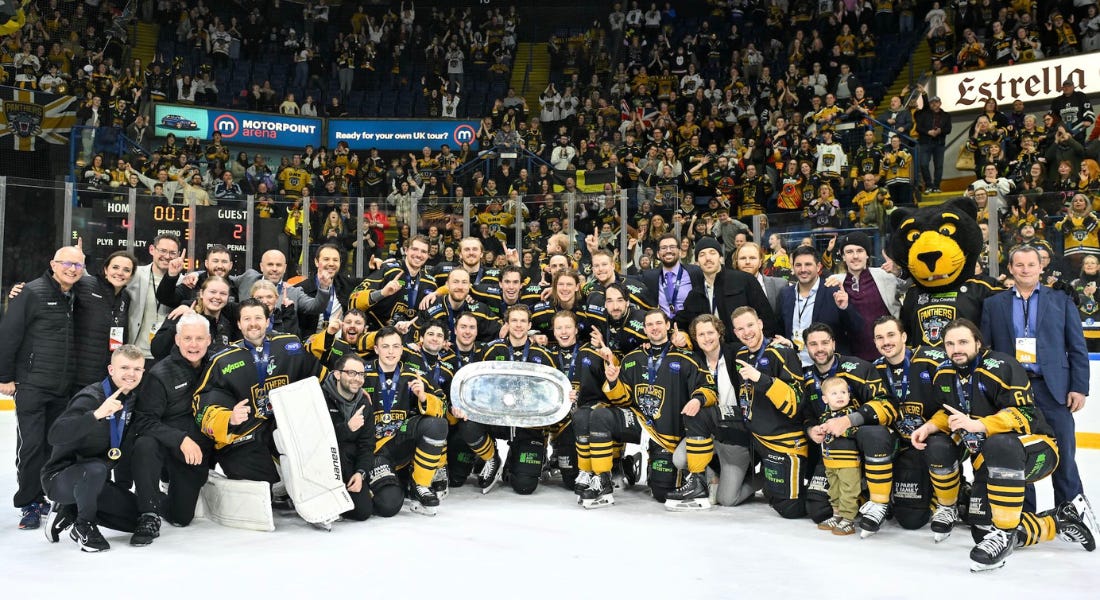 A group picture of the Nottingham Panthers hockey players in front of the crowd holding a silver trophy