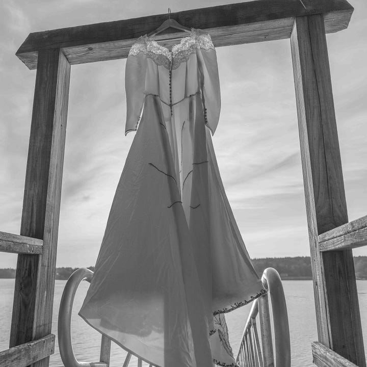Diptych: Two black and white photographs. On the left, a satin wedding dress hangs from a rectangular wooden arch. It is translucent. The sun sets behind; On the right, a formal wedding portrait of a young woman in her dress holding a large bouquet of flowers.