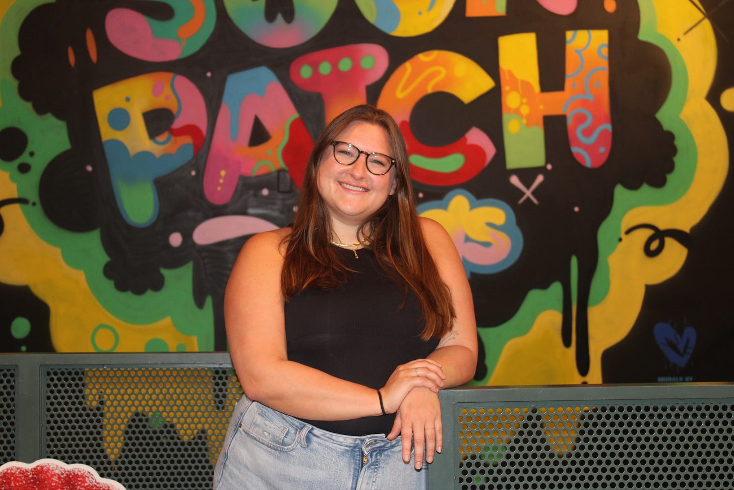 Shelby standing in front of a Sour Patch Kids sign Shelby standing in front of a Sour Patch Kids sign
