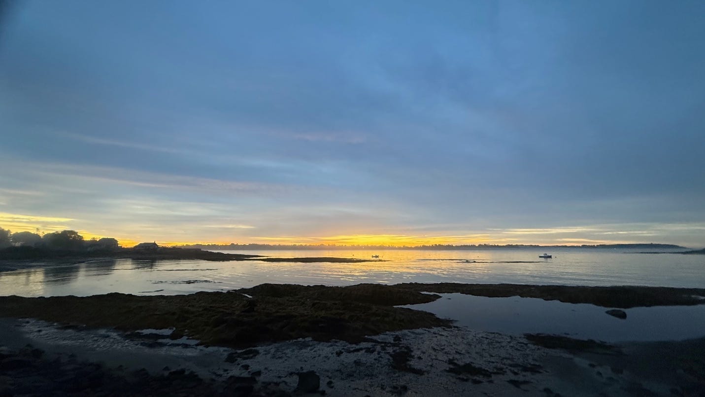 A body of water with a rocky shore and a sunset

AI-generated content may be incorrect.