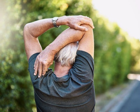 Rear view shot of a senior man warming up before a run outside
