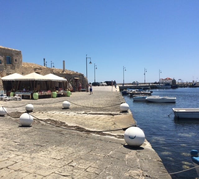bounganvilla, coffee granita with panna colorful chair and stone buildings in Siciliy cannoli prickly pear cactus Sicily the blue sea