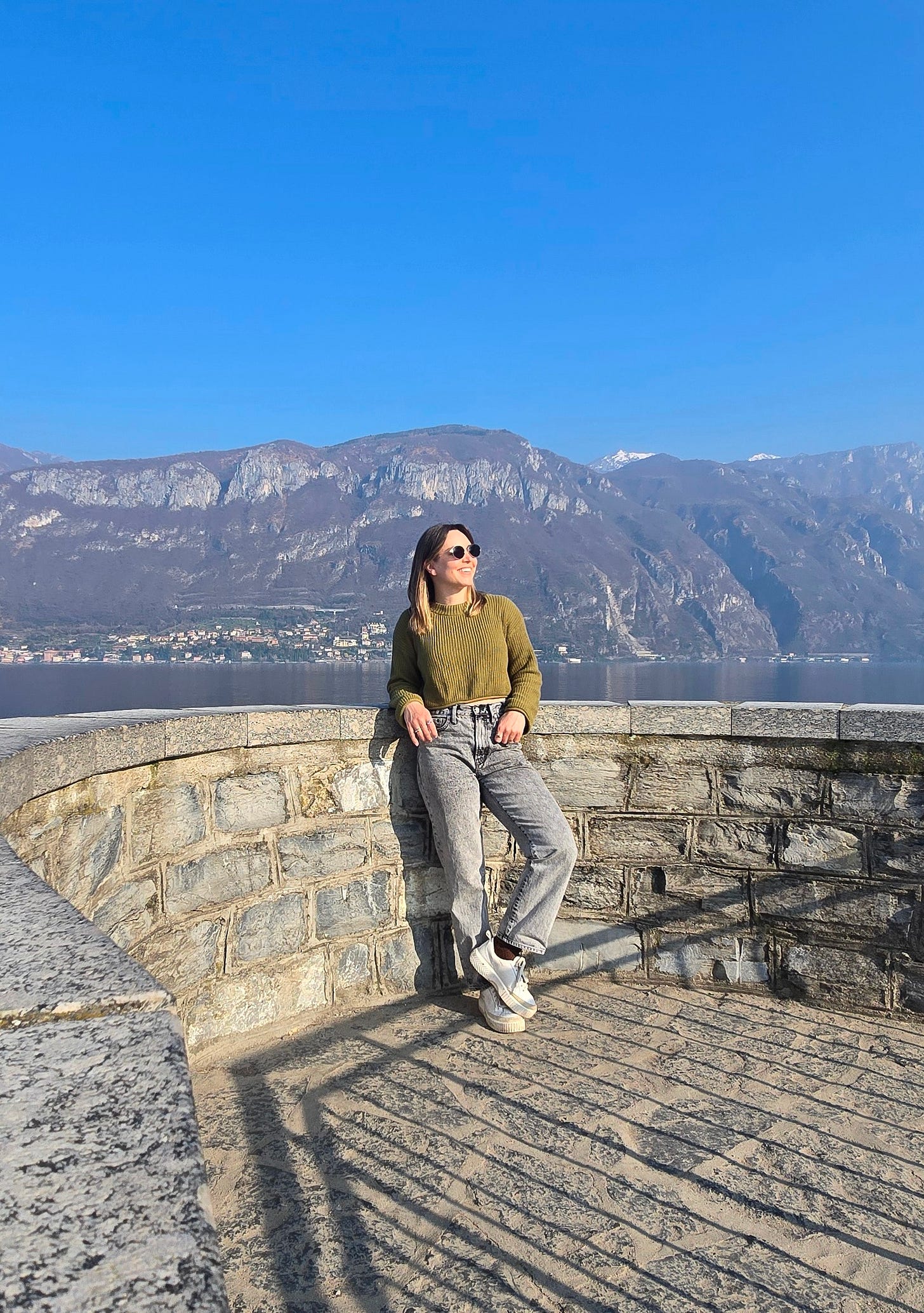 Cassidy standing in front of Lake Como, with mountains in the background Cassidy standing in front of Lake Como, with mountains in the background